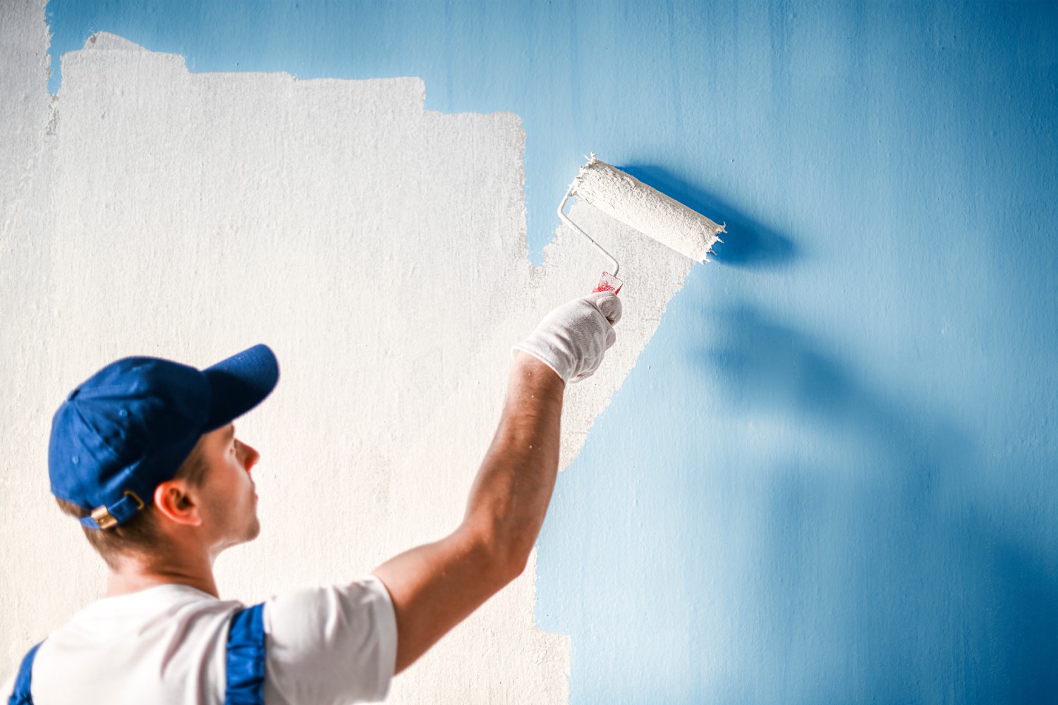 Painter painting a wall with paint roller