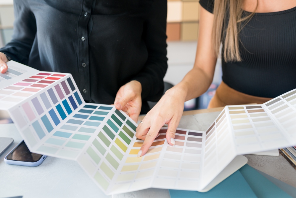 two women choosing samples of wall paint