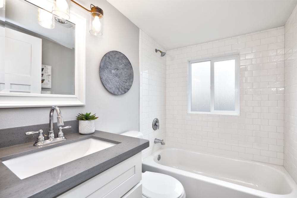 Modern bathroom interior with white vanity topped with gray countertop